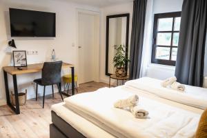 een hotelkamer met 2 bedden en een bureau bij Hotel Kavala in Lohmar