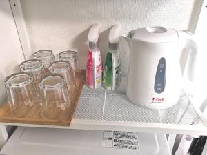 un aparato blanco sentado en un estante en un refrigerador en DP House, en Tokio