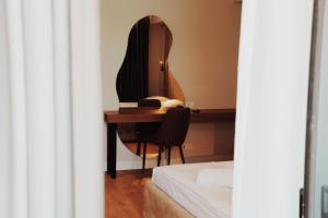 a bedroom with a desk and a mirror at Oniro by Iliria Palace in Himare