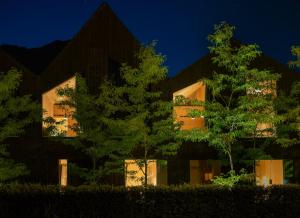 ein Gebäude mit Bäumen in der Nacht davor in der Unterkunft quartier - über Nacht in besonderer Architektur in Garmisch-Partenkirchen