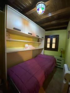 1 dormitorio con 1 cama de color púrpura en una habitación en La herradura, acogedora casa en Montemayor del Río, en Montemayor del Río