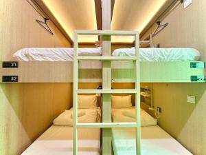 a bunk bed room with two bunk beds in it at THE ROOM Capsule Hotel in Singapore