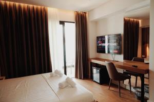 a hotel room with a bed and a desk and a computer at Oniro by Iliria Palace in Himare
