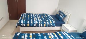 a bedroom with a bed and a blue and yellow bedspread at Adan beach in Aourir