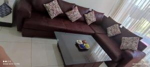 a brown leather couch with pillows and a glass table at Adan beach in Aourir