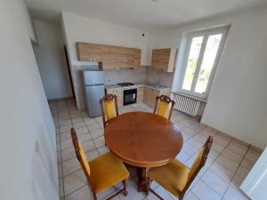 VILLA AIDA LAKE VIEW في لافينا بونتي تريسا: مطبخ مع طاولة وكراسي خشبية في الغرفة