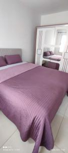 Adan beach في أورير: غرفة نوم مع سرير أرجواني مع بطانية أرجوانية