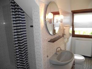 y baño con lavabo, espejo y aseo. en Villa Du Lion D'or, en La Petite-Pierre