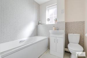 a bathroom with a tub and a toilet and a sink at Silver Stag Properties, 3 BR w Parking and Garden in Smisby