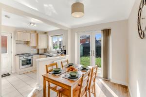a kitchen and dining room with a table and chairs at Charming 3-Bed Home with Garden & Parking in Smisby
