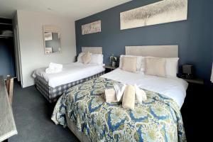 two beds in a room with blue walls at Dog and castle in Wood Walton