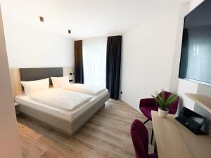 um quarto com uma cama, uma mesa e cadeiras em HOLI City Apart Hotel Berlin em Berlim