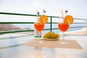 two glasses of orange juice and a plate of grapes at Apartamento Vista Atlántico Puerto Rico in Mogán