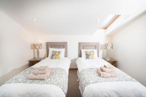 two beds in a room with pink towels on them at Atlas in Nairn