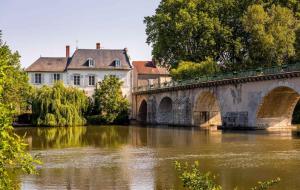 Saint-Hilaire-Saint-Mesmin的住宿－La Tiny House au bord de l'eau，一座建筑物前的河上桥梁