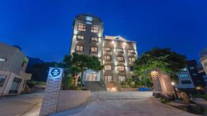 a large building with a sign in front of it at Geoje Mongdol Beach H Avenue Hotel in Geoje