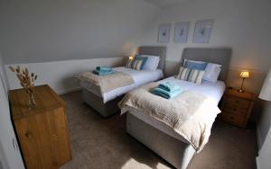 um quarto com duas camas e uma mesa de cabeceira em Clover Cottage countryside retreat with sea views em Crail