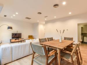 a dining room with a table and chairs and a couch at apartamento en plaza de canalejas in Madrid