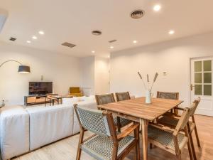 a dining room with a table and chairs and a couch at apartamento en plaza de canalejas in Madrid