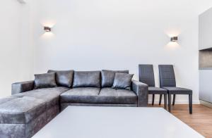 een woonkamer met een bank en 2 stoelen bij apartamentos reformados con garajes incluido in San Sebastián de los Reyes