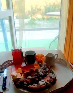 a plate of food on a table with two cups and drinks at Къща за гости Вълчеви Несебър in Nesebar