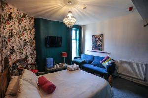 a living room with a bed and a blue couch at Ferny House in Blackpool