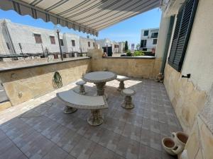 d'une terrasse avec une table et des bancs sur un balcon. dans l'établissement Costa Saracena Sole, Mare e Relax, à Augusta