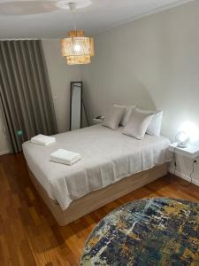 a bedroom with a large bed with white sheets and a rug at Ocean SC Apartment in Santa Cruz
