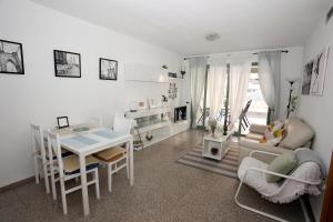 a living room with a table and a dining room at Apartamento dos habitaciones primera línea de playa in Valencia