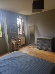 1 dormitorio con cama, escritorio y tocador en Gite du Dolmen classé 3 épis, en Blessac