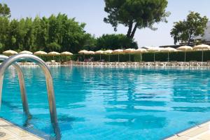 a swimming pool with chairs and umbrellas at Eraora Hotel Village in Battipaglia