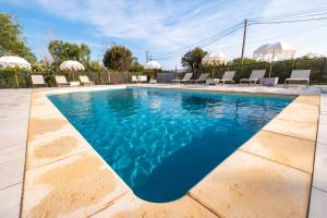 - une piscine d'eau bleue et des chaises longues dans l'établissement Hôtel & Restaurant Les Mouettes, à Belgodère