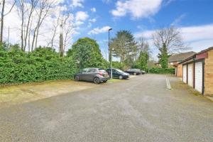 a parking lot with two cars parked next to a building at Spacious 2-bed flat with free parking in Croydon