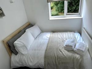 a bed in a small room with a window at Spacious 2-bed flat with free parking in Croydon