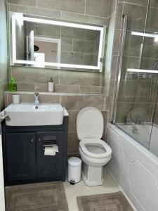 een badkamer met een wastafel, een toilet en een bad bij Spacious 2-bed flat with free parking in Croydon