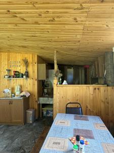 Habitación con mesa y techo de madera. en Pirikiti, en Akhmety