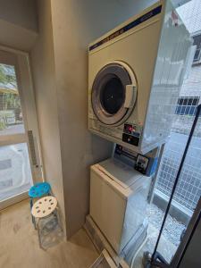 a washer and dryer in a room with a washing machine at HOTEL TOMOS ASAKUSA in Tokyo