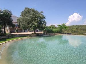 uma grande piscina de água azul clara num quintal em Villa 10 P piscine lagon avec vue époustouflante proche Uzès em Saint-Maximin