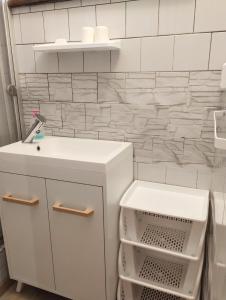 a white bathroom with a sink and a counter at Pension Sport Ostružná in Ostružná