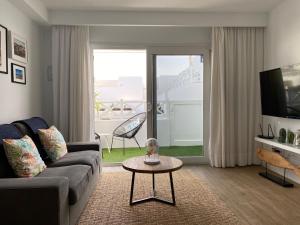 un soggiorno con divano e tavolo di Flower Beach suite Pool a Playa Honda