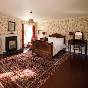 a bedroom with a bed and a fireplace at Tullymurry House in Newry