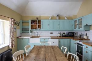 a kitchen with blue cabinets and a wooden table at Merrion Mews in Dublin