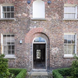 wejście do ceglanego budynku z łukiem w obiekcie Merrion Mews w Dublinie