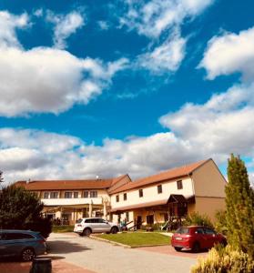 un edificio con coches estacionados en un estacionamiento en Active Wellness hotel U zlaté rybky, en Vyškov