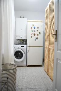 a kitchen with a refrigerator and a washing machine at Casa Humulesti, fii vecinul lui Ion Creanga in Târgu Neamț