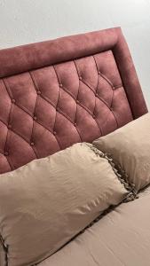 1 cama con cabecero rosa y almohada en Cortijo Borreguero en Villanueva del Trabuco