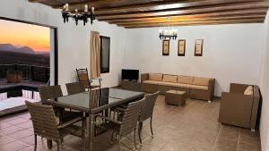 una sala da pranzo con tavolo, sedie e divano di Cortijo Borreguero a Villanueva del Trabuco