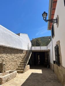 una escalera que conduce a un edificio con una puerta en Cortijo Borreguero en Villanueva del Trabuco