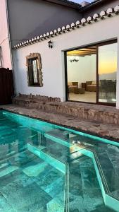 a swimming pool in a house with a glass floor at Cortijo Borreguero in Villanueva del Trabuco
