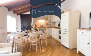 a kitchen with a table and a white refrigerator at Daplace - Gae Apartment in Milan